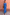 Thumbnail for Blue Eye Mesh Maxi Dress with pink heart and eye motifs and long sleeves, worn by a model against a terracotta wall.