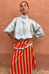 Blue Stripe Batwing Blouse with voluminous sleeves and high neck, styled with a red striped mini dress.