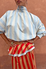 Blue Stripe Batwing Blouse with a high neck and shirred cuffs, paired with a red and tan striped ruffled skirt.
