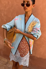 Blue Mystical Cardigan with golden sun jacquard motifs and contrast brown trims, styled with a leopard print lace skirt.