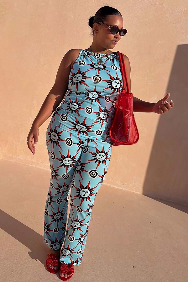 Blue Sun Foldover Trousers in bright blue jersey with sun and swirl motifs, styled with a matching co-ord vest.