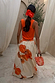 Blurred Floral Midi Skirt in cream cotton with orange floral motifs, shown from the back with a coral tank top.