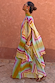 Bright Geo Stevie Maxi Dress with a colourful geometric print and cape sleeves, shown in a side profile.