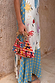 Multi-wear Celestial Patti Dress with sun and star motifs, paired with a beaded red and white diamond-patterned bag.