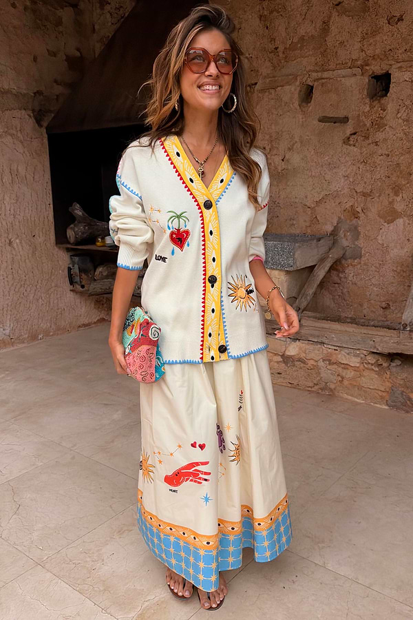 Celestial Talia Skirt in white cotton with colourful sun and palm motifs, worn with a matching cardigan.