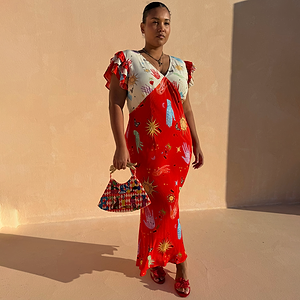 Red Celestial Midi Dress featuring a cream blouson top, red bias-cut skirt and iconic sun and hand prints.