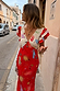 Red Celestial Midi Dress featuring a cream celestial print, V-neckline and ruffled sleeves on a street.