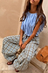 Blue and tan Check Balloon Trousers with a relaxed draped silhouette and drawstring waist on a seated model.