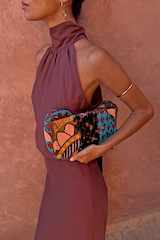 Sleeveless Chocolate Billie Top with a high scarf neckline and gathers, styled with a colourful beaded clutch.