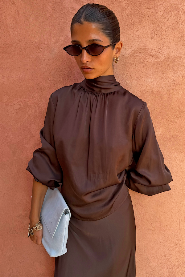 NFD Chocolate Tie Neck Blouse in satin with volume sleeves and a high neck, styled with a light blue clutch.