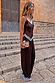 Chocolate wide-leg satin trousers with blue lace trim, styled as a co-ord with a matching top on stone steps.
