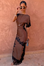 Vestito Fearne cioccolato con pizzo nero, bordi delicati e maniche corte su una parete texturizzata.