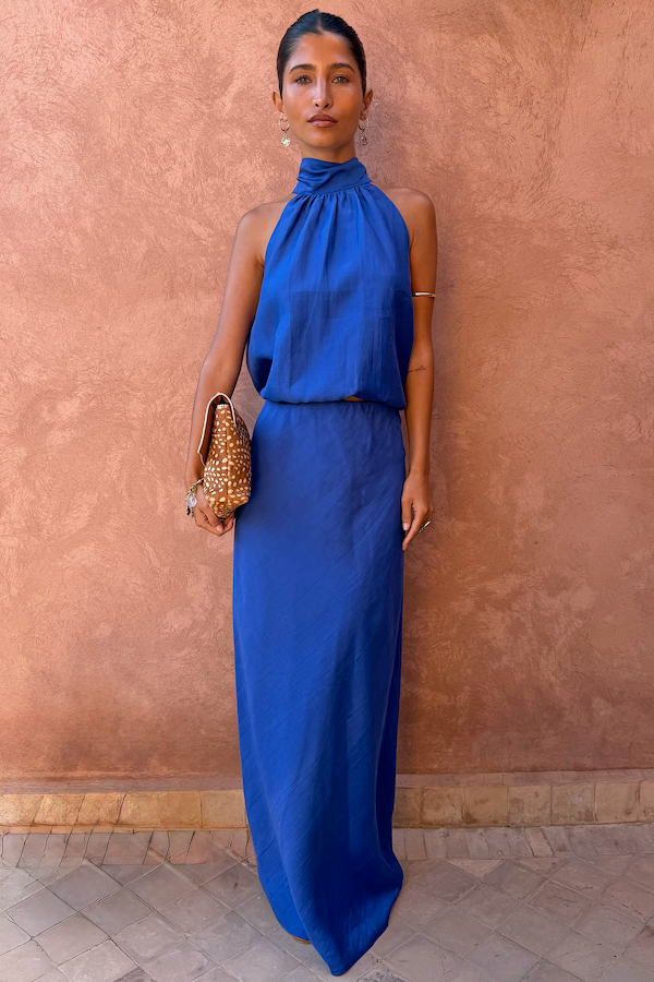 Vibrant Cobalt Daphne Skirt and matching halter top co-ord, styled on a model against a textured wall.