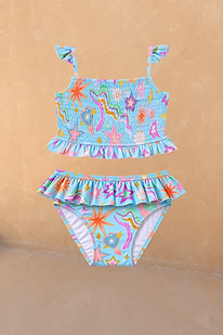 Girl's Starburst Crop Bikini Set featuring a blue smocked top and ruffle-waisted bottoms with a colourful star print.