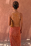 Fawn Rib Tank Top with tan spots and gold back embroidery, worn with a matching skirt against a terracotta wall.
