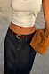 Dark blue denim pencil midi skirt styled with a white ribbed vest, burgundy belt and tan bag.