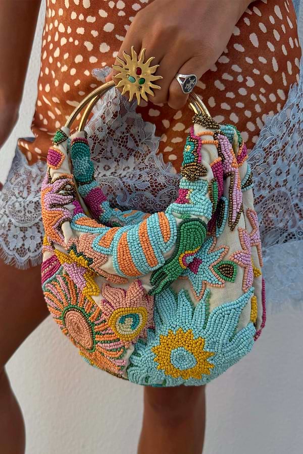 Dreamer Bag with multicoloured glass bead embroidery, sun and swirl motifs and a gold metal bar handle.