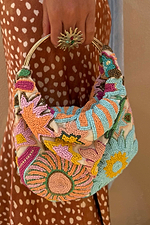 Dreamer Bag featuring multicoloured glass bead embroidery in sun and star motifs with a gold metal bar handle.