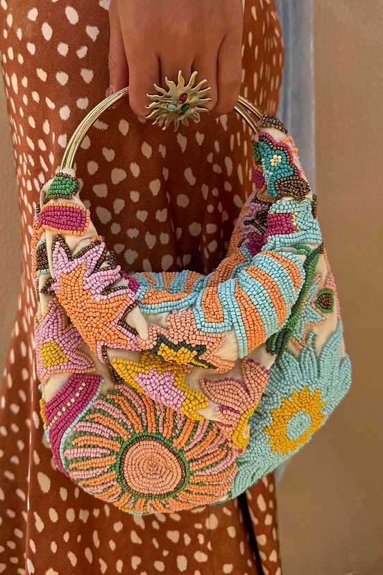 Dreamer Bag featuring multicoloured glass bead embroidery in sun and star motifs with a gold metal bar handle.