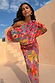 Fruit Tilly Dress in pink with a citrus print, metallic flecks, and an off-shoulder draped top.