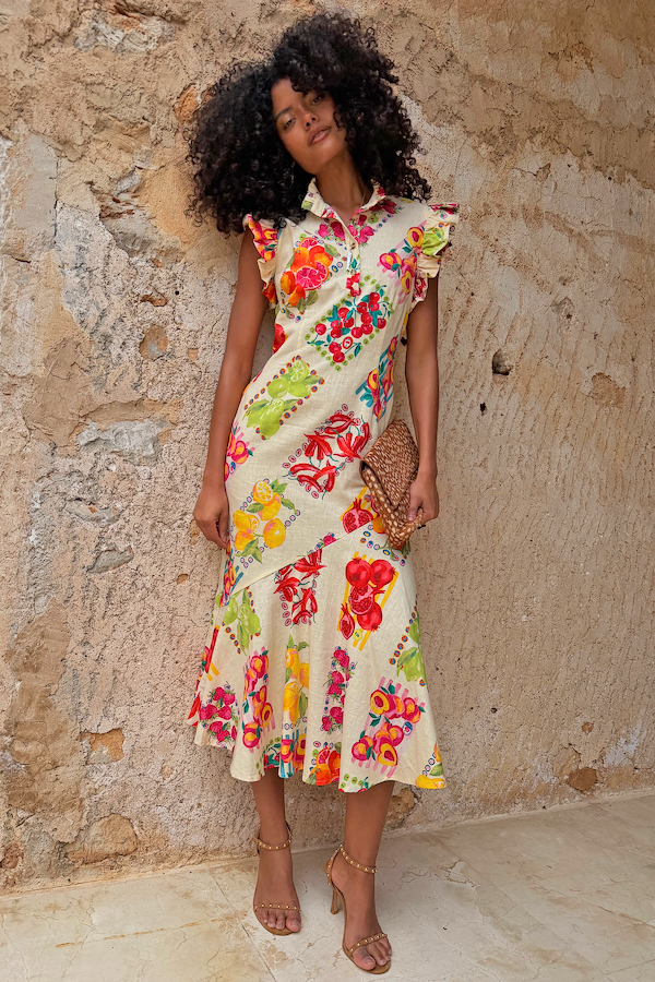 Fruit Stamps Remi Dress in white cotton linen featuring a fruit sticker print, ruffle sleeves and asymmetric hem.