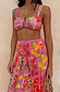 Pink Fruit Stamps Skirt with a Mediterranean fruit print and shirred waistband, paired with a matching bikini top.