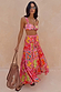 Pink Fruit Stamps Skirt with a Mediterranean fruit print, shirred waistband and side split on a model.
