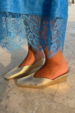 Metallic Gold Wedge Mule with a pointed toe and sculpted heel, paired with a blue lace dress.