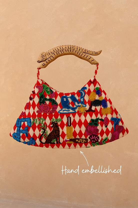 Cirque Bag with red diamond checks, hand-beaded alphabet motifs and a carved wooden animal-shaped handle.