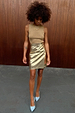 Metallic Gold Vegan Leather Mini Wrap skirt styled with a sleeveless top and light blue heels.