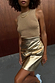 Gold vegan leather mini wrap skirt paired with a metallic sleeveless top and gold jewellery.