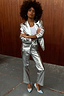 Silver Vegan Leather Trouser and matching blazer styled with light blue heels against a wooden wall.