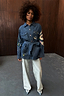 Blue Denim Manifestation Jacket with tarot-inspired embroidery and a tie-waist, paired with wide-leg light wash jeans.