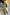 Thumbnail for Khaki Vegan Leather Trousers styled with a green pleated off-the-shoulder top with gold metallic spots.