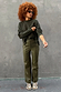 Khaki Vegan Leather Trousers paired with a dark green jumper and leopard print trainers.