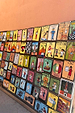 Vibrant hand-painted folk art signs on a wall depicting characters and professions in Marrakech.