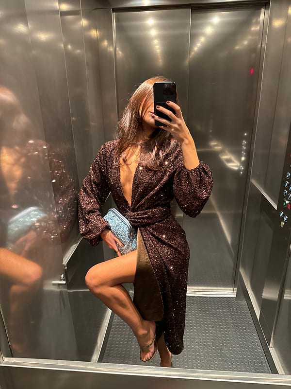 Chocolate Sequin Vienna Dress with voluminous sleeves and multi-wear wrap waist, shown in a lift mirror selfie.