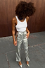 Thumbnail for Metallic Silver Vegan Leather Trousers styled with a white tank top and matching pointed heels for a street style look.