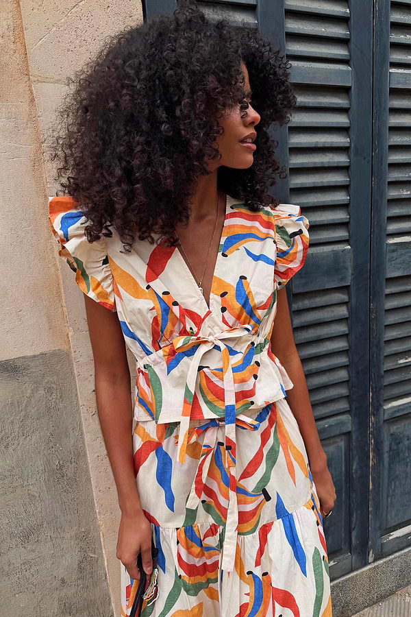 Banana Kerri Top in cream with a banana print, featuring a tie-front waist and ruffled sleeves.