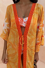 Yellow Sun Kimono in Soleil print with orange lace trim and tie front detail over matching swimwear.