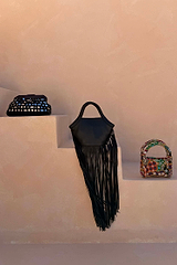 Black Leather Fringe Bag with long tassels and a plaited handle, styled on neutral steps with other bags.