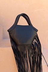 Black Leather Fringe Bag with a plaited handle and long fringe details, resting on a neutral stone background.