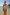 Thumbnail for Morocco Swimsuit with a pink and blue swirling patchwork print and belted waist, worn in shallow beach water.