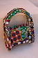 Morocco Beaded Bag featuring hand-beaded abstract designs in autumnal tones with a matching beaded handle.