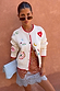 Cream Morocco Charms Cheryl Cardigan with red trim and iconic motifs, styled with a spotted lace-trim skirt and clutch.