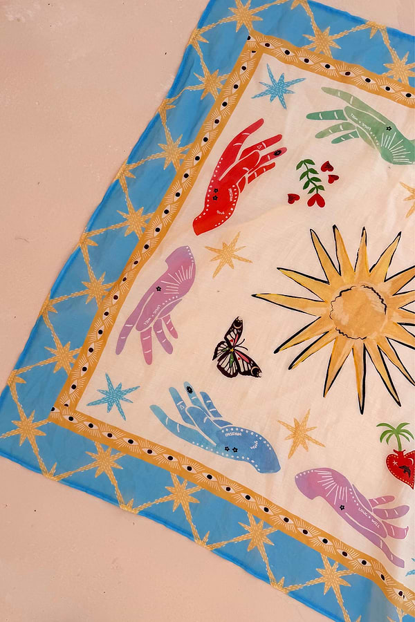 Celestial Bandana featuring a blue border with hand-painted sun, palm, eye, and mystical hand motifs.