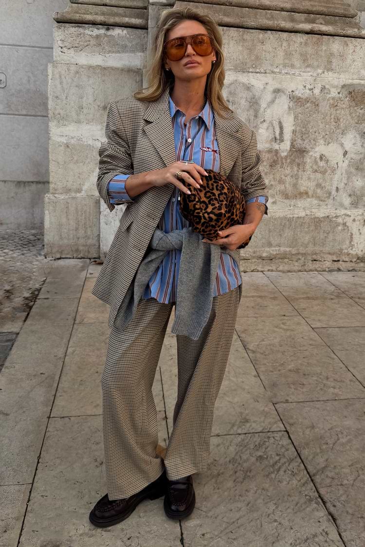 Grey check trousers and matching blazer co-ord styled with a blue striped shirt and leopard print clutch bag.