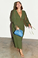 Khaki Celia Plisse Dress with sheer tie sleeves and v-neck, styled with a blue clutch on a smiling model.
