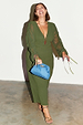 Khaki Celia Plisse Dress with sheer tie sleeves and v-neck, styled with a blue clutch on a smiling model.