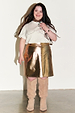 Gold Vegan Leather Mini Wrap skirt styled with a white graphic t-shirt and tan over-the-knee boots.